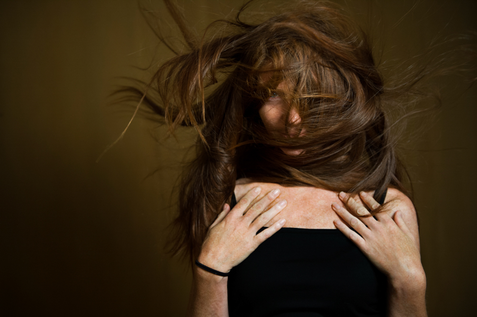 Portrait of woman with long messy hair covering her face