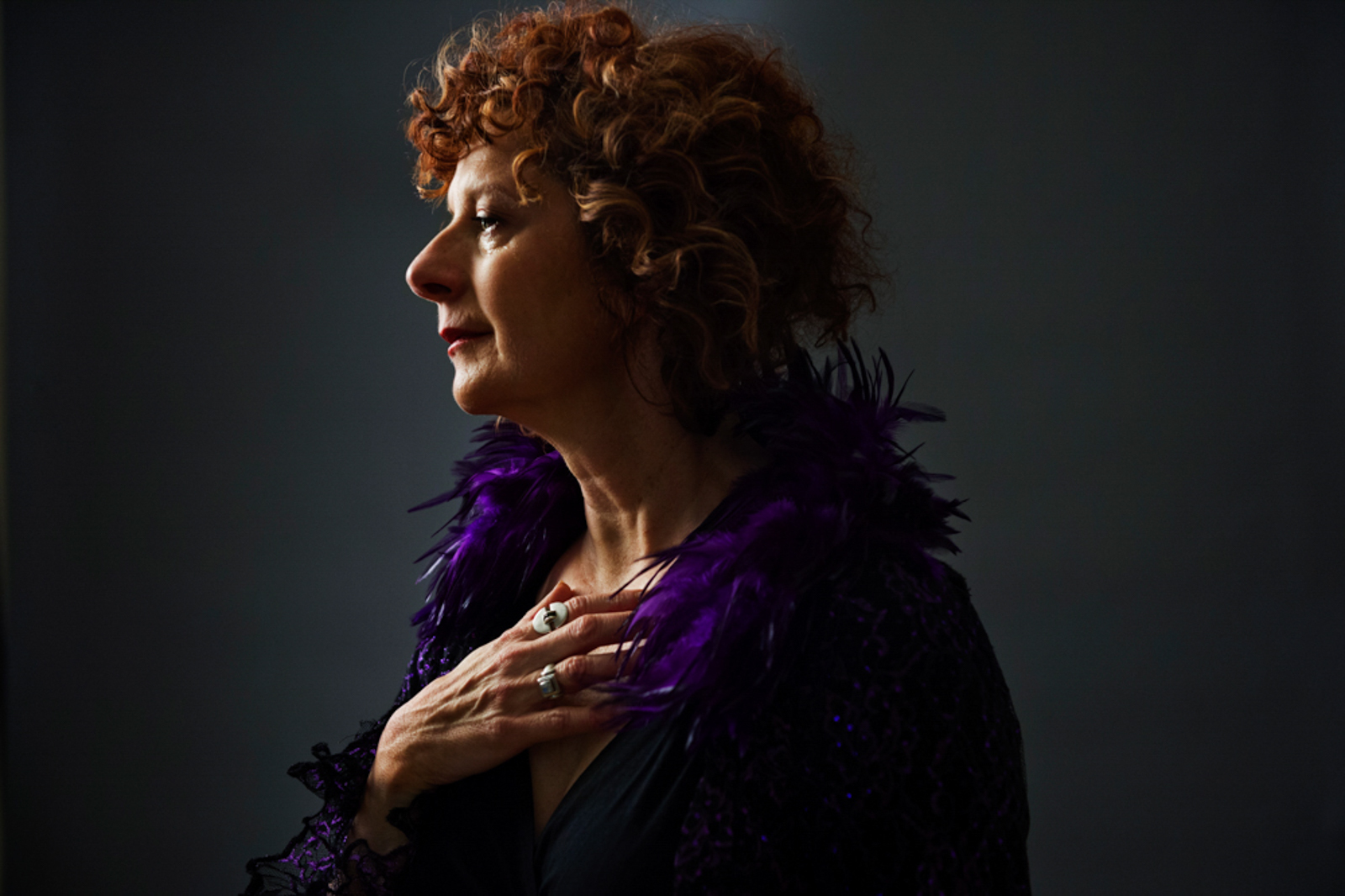 Portrait of woman with red hair and purple coat looking pensive