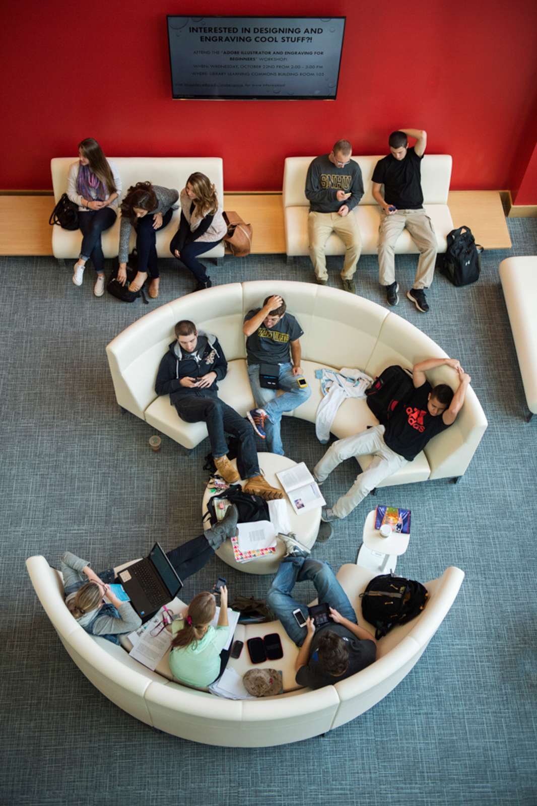 Overhead shot of students sitting on round couches socializing