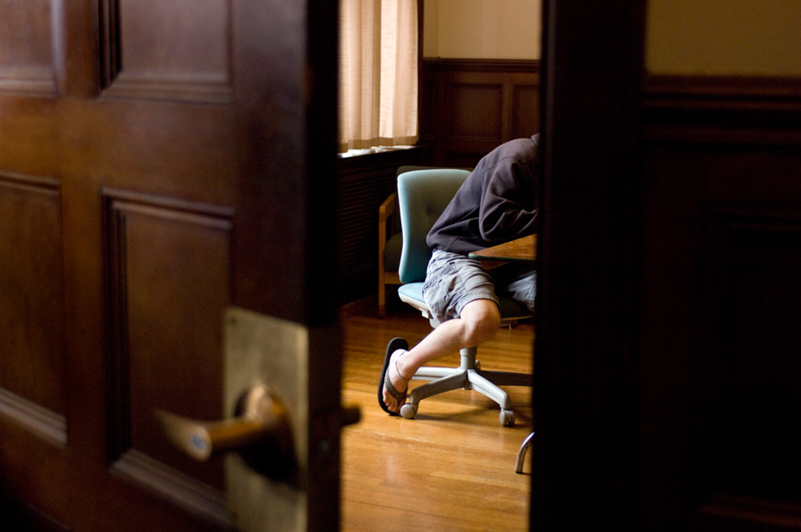 Student working in room seen through an open door wearing flip flops