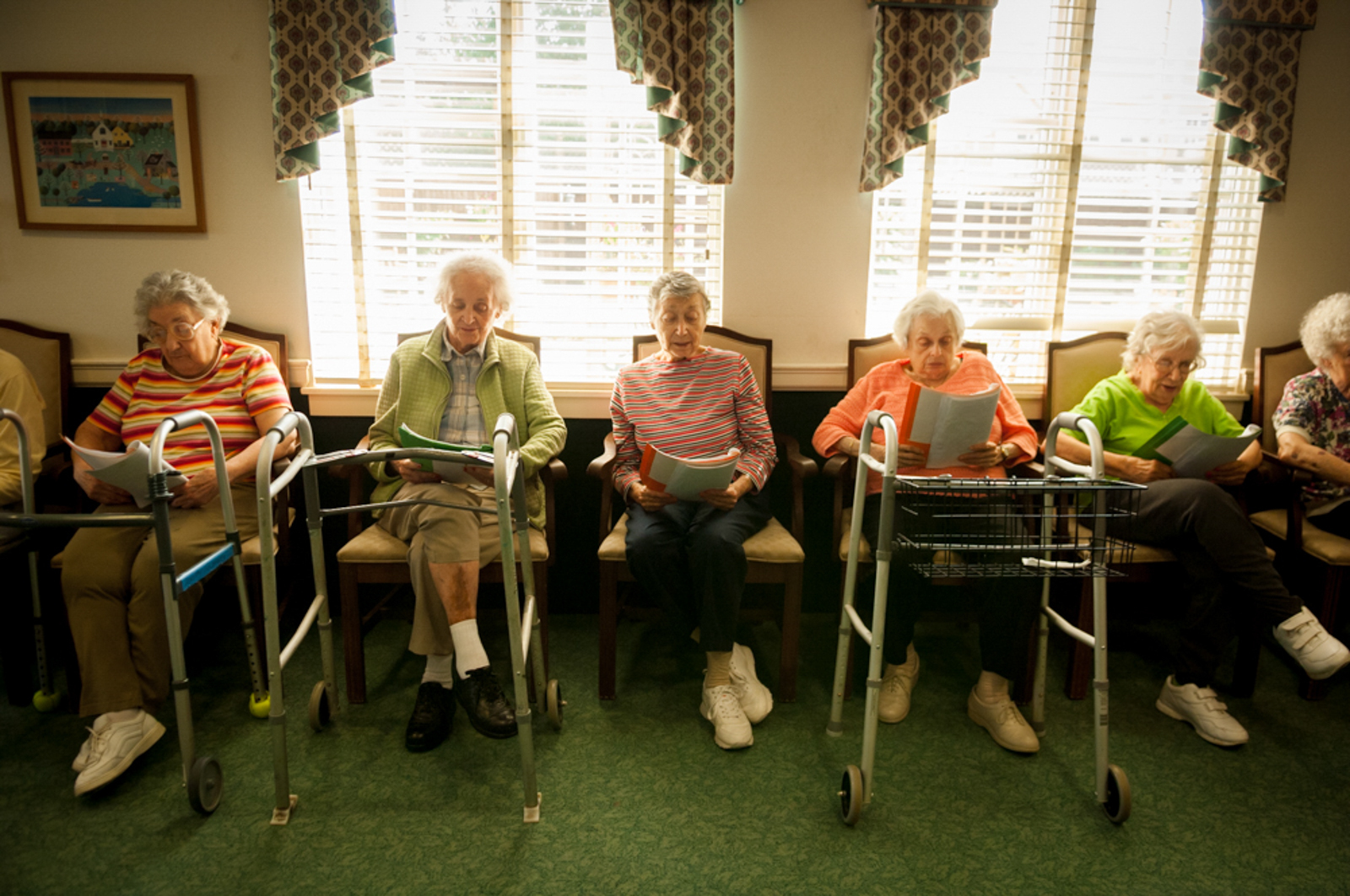 Group of elderly women sitting in cozy room reading