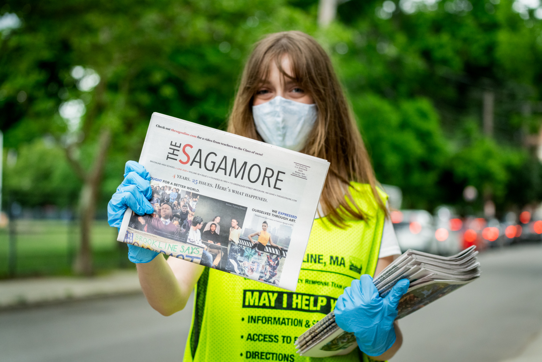 tween holding newspaper in gloves and mask