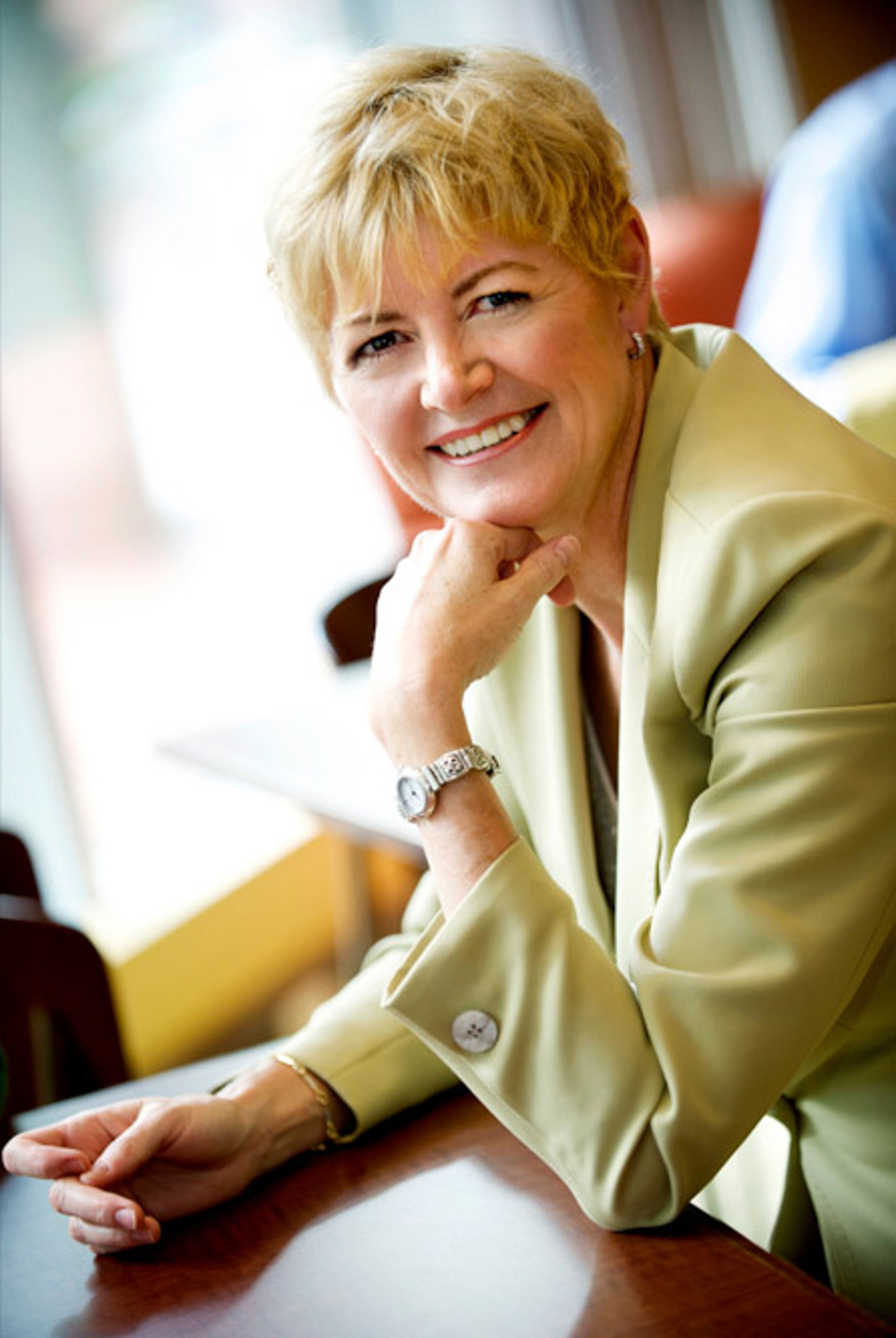 Portrait of business woman smiling leaning on a desk