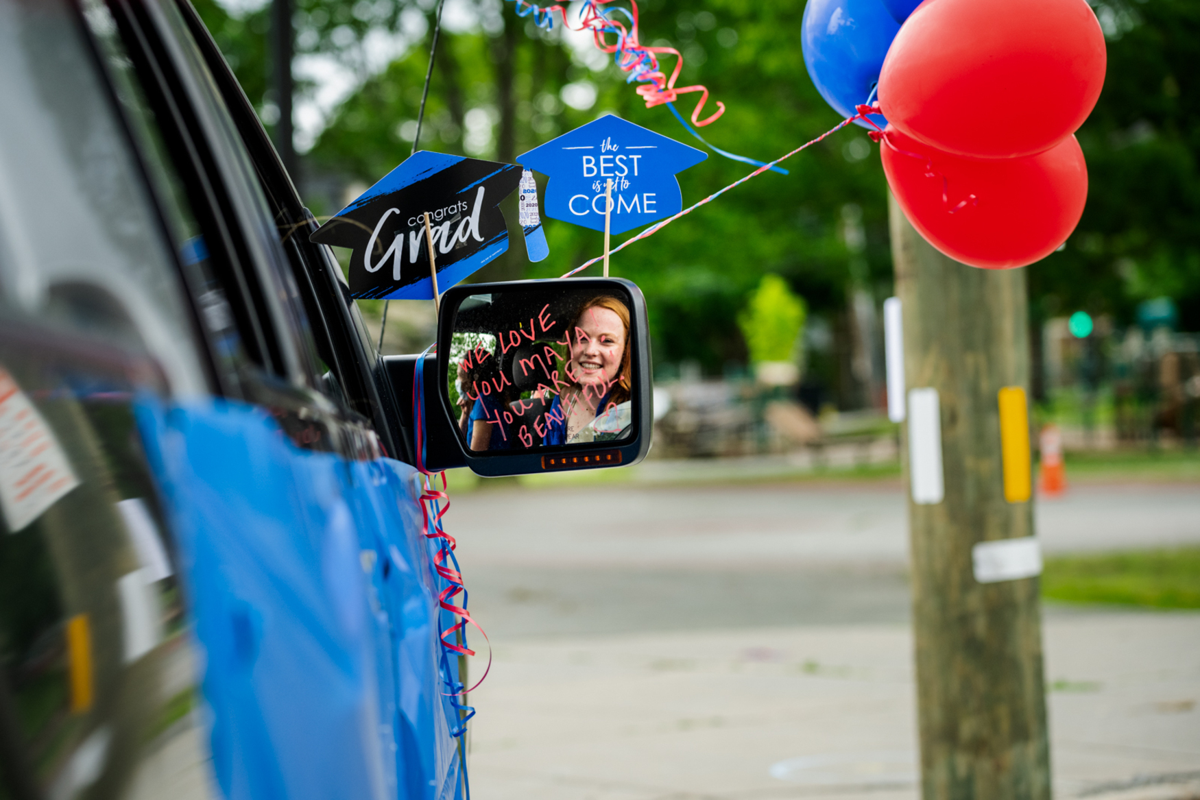 high school graduate in side view mirror with balloons