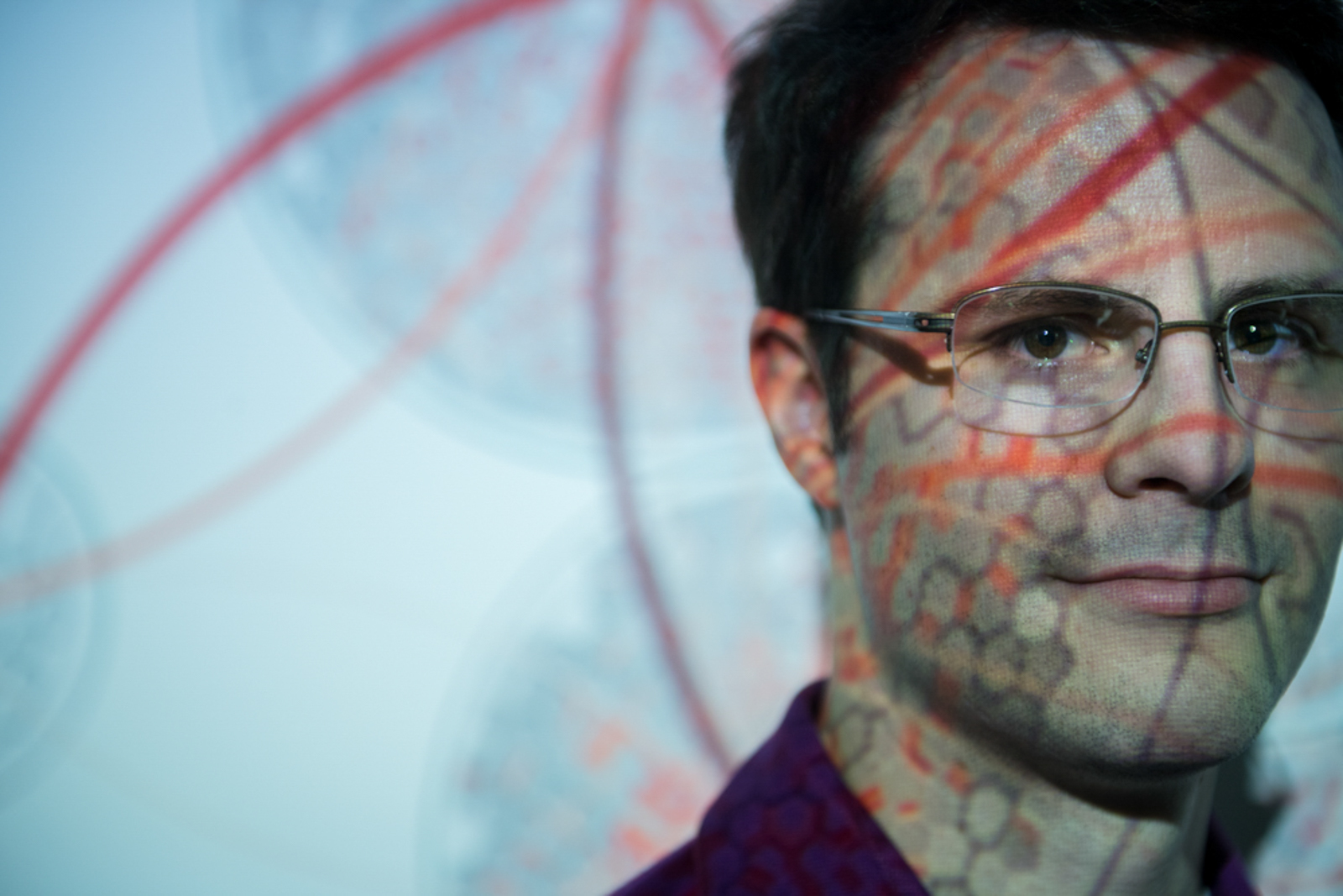 Close up of man wearing glasses with pattern projected over his face