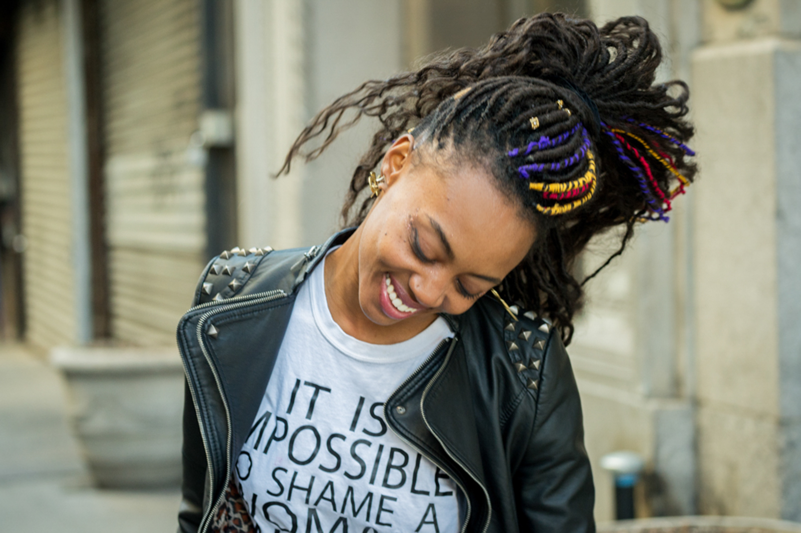 Portrait of woman with dreadlocks and leather jacket smiling in motion